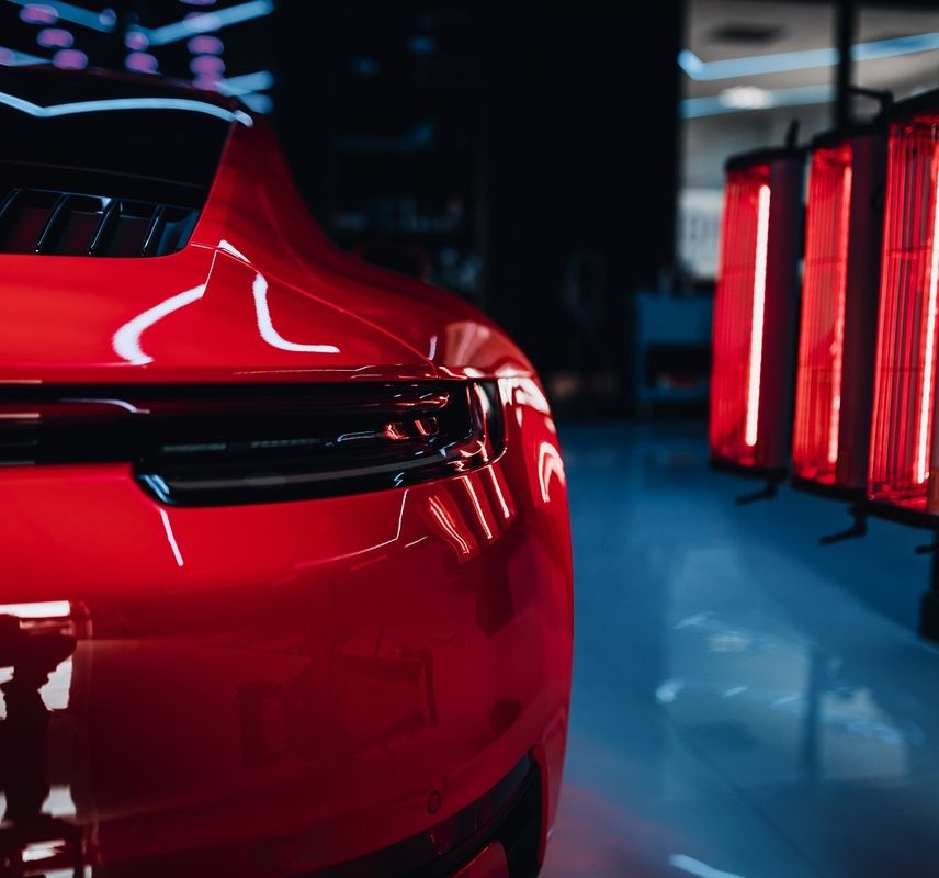 Roter Sportwagen wird von rotem Licht angestrahlt